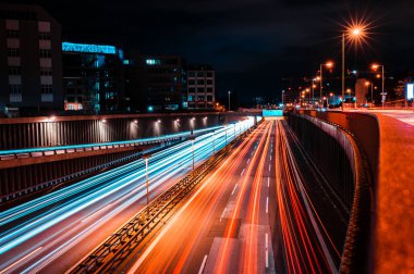 Berlin 'in Tempelhof kentsel otobanının geceleyin ortaya çıkması. Geniş otoyol, araba farlarının ışıkları. Günbatımından sonra hareket ve metropol hayatı.