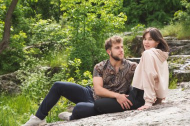 Güzel bahar ya da yaz manzarası, göl kenarındaki yeşil ağaç yaprakları arasında, birbirine sarılıp öpüşen, birbirine bakan ve eğlenen genç çiftler. İlişkilerde şefkat