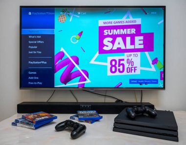 Chengdu, Çin, 12 Ağustos 2019. PS4 oyun mağazasında yaz indirimi. Ön sipariş, indirme, evdeki büyük LCD ekranda Sony Play Station 4 Pro oyunu. Kontrolcü elinde..