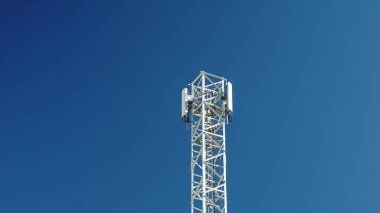 Mavi gökyüzüne karşı beyaz cep telefonu anteni