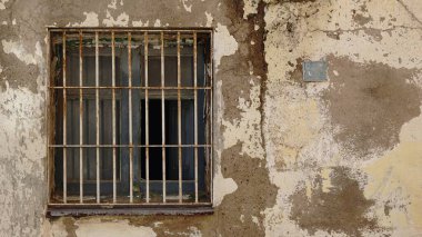 Terk edilmiş ön cephesinde ızgara olan rustik pencere