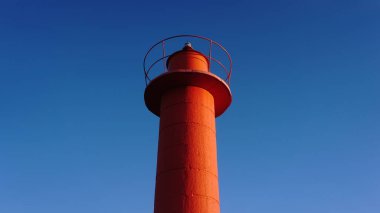 Mavi gökyüzüne karşı kırmızı deniz feneri kulesi