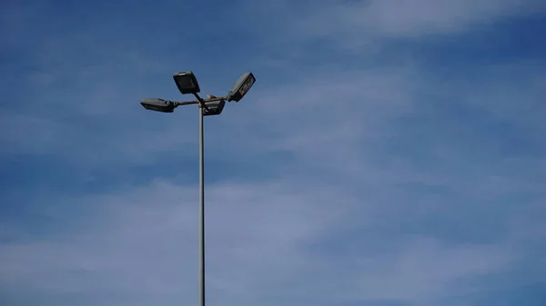 Městská Pouliční Osvětlení Pozadí Proti Oblačné Obloze — Stock fotografie