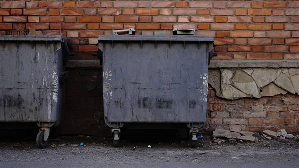 industrial rubbish bins against brick wall