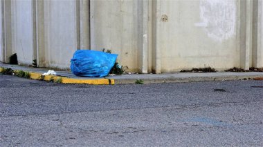 Sanayi bölgesinde bir kaldırımda çöp torbası.