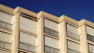building facade with lowered window shutters