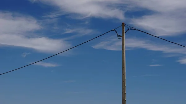 空を背景にした電話ケーブルの棒 — ストック写真