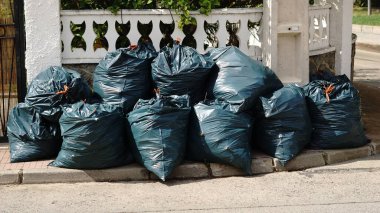 Kaldırıma istiflenmiş çöp torbaları.