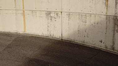 Eğri lekeli beton duvar buluşması karanlık, desenli asfalt kaldırım