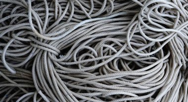 Gerilim altında istiflenmiş endüstriyel ipler, tekrar eden mekanik işçilik izleri taşıyan lifler.