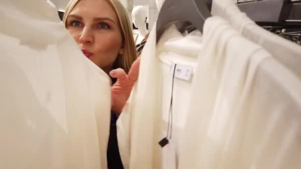 Menina escolhe roupas no shopping . — Vídeo de Stock