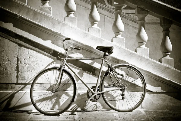 Old bicycle against a marble wall — Stock Photo, Image