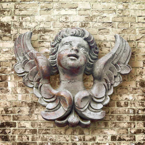 Escultura de madeira de um anjo italiano contra uma parede de tijolo — Fotografia de Stock