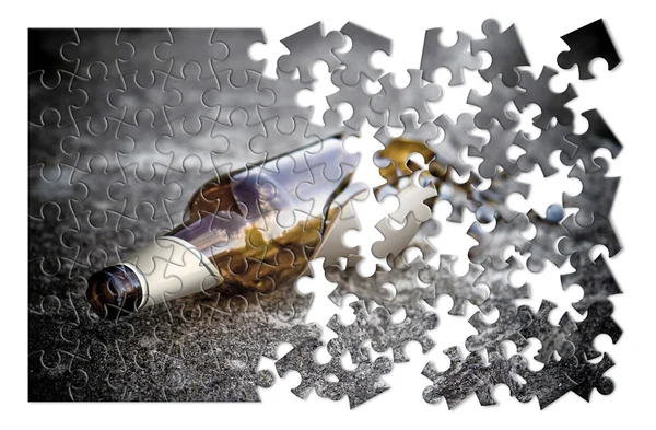 Puzzel van een gebroken flesje bier op de grond rusten — Stockfoto