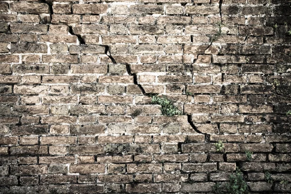 Mur de briques fissurées - fissure profonde dans un mur de briques - image tonique — Photo