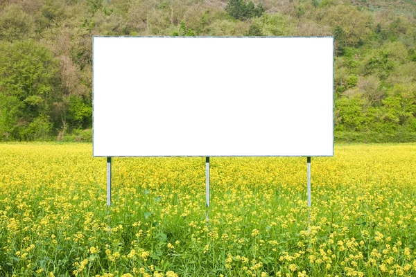 Blank commercial advertising billboard immersed in a rural scene against a yellow flowery field - image with copy space