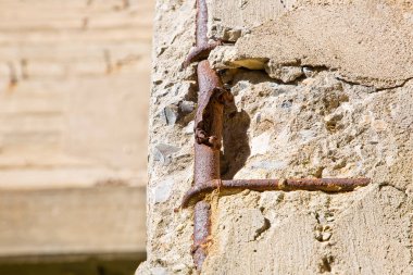 Hasarlı ve paslı metalik destek çubukları olan eski güçlendirilmiş beton yapı.