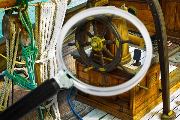 Learn to sail - Old wooden boat moored on calm water - Concept image seen through a magnifying glass.