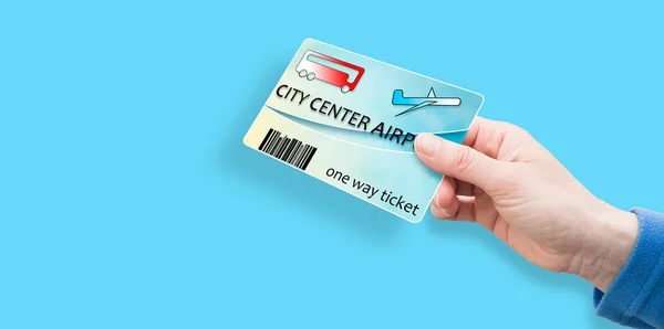 Female hand holds Bus tickets from city center to airport and return - concept image with copy space.