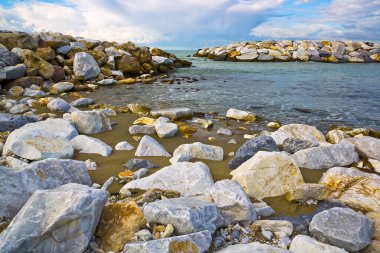 Toskana kıyısında kaya kıran suyu olan sessiz bir koy (İtalya).