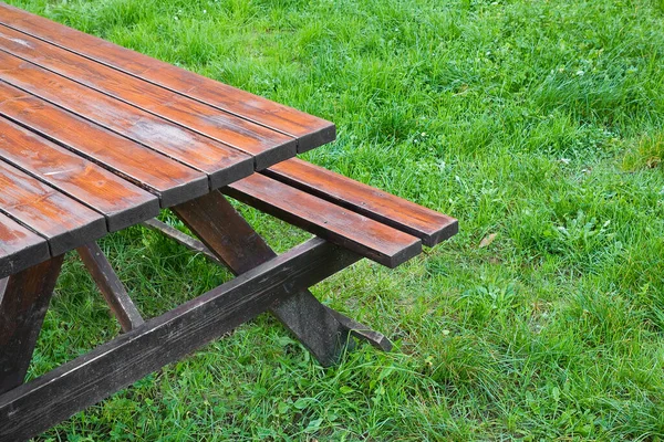 公园绿色草地上的木制空野餐桌 — 图库照片
