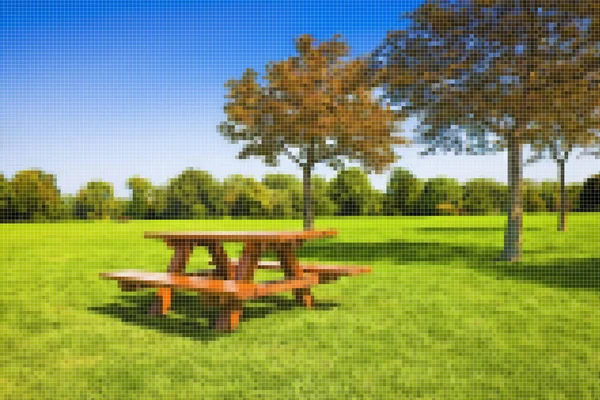 背景上有树木的绿色草地上的野餐桌 具有像素化效果的概念图 — 图库照片