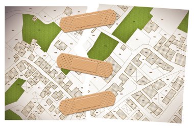 Binaların, yolların ve arazi parsellerinin olduğu hayali bir kadastro haritasının yırtılmış fotoğrafı. Yapışkan bandajlı konsept görüntü..