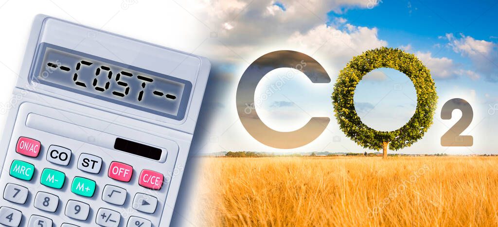 Costs about reduction of the amount of CO2 emissions - concept with CO2 icon text and tree shape in rural scene with calculator.
