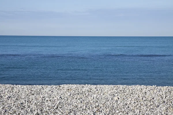 Calm sea with white stones on the beach