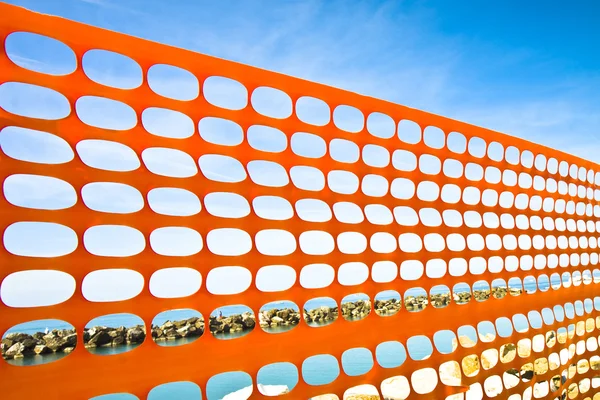 Red de plástico naranja alrededor de un sitio de construcción en la costa — Foto de Stock