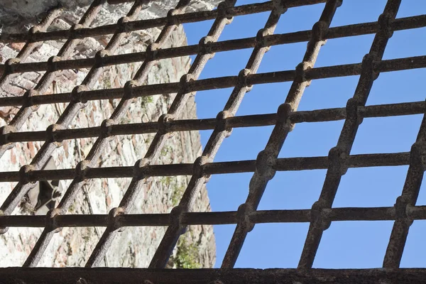 Металлическая решетка против голубого неба - концепция свободы — стоковое фото