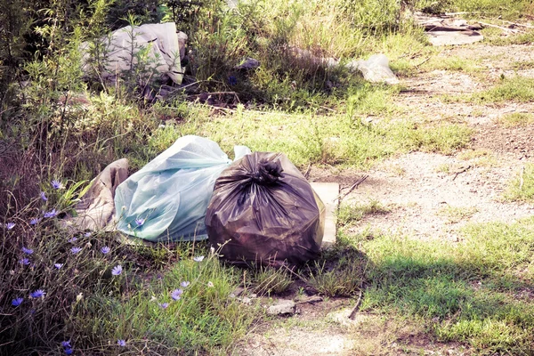 Despejo ilegal na natureza; sacos de lixo deixados na natureza  - — Fotografia de Stock