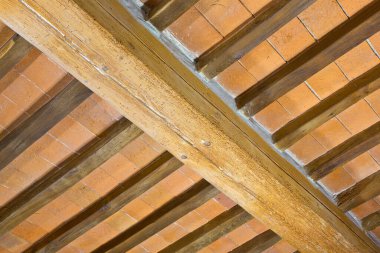 OLD TRADITIONAL ITALIAN WOODEN CEILING WITH WOODEN BEAMS, RAFTERS AND TERRACOTTA TILES CLAY BRICKS in italian language called mezzane - Tuscany culture - Italy