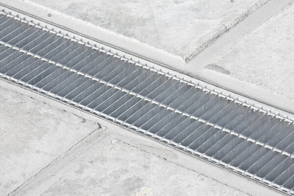 GALVANIZED INDUSTRIAL STEEL RAINWATER COLLECTION GRATE in a parking lot with concrete flooring - Drainage channel on concrete surface