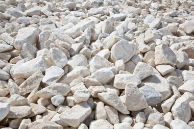 İnşaat sektöründe kullanılan bir inşaat sahasında beyaz farklı boyutlarda çakıl taşları ve yol yataklarının inşası için inşaat faaliyetleri