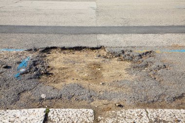 Çukur çukurları araçların geçişi için tehlikeli olan tehlikeli asfaltlı eski kırık ASPHALT Yolu
