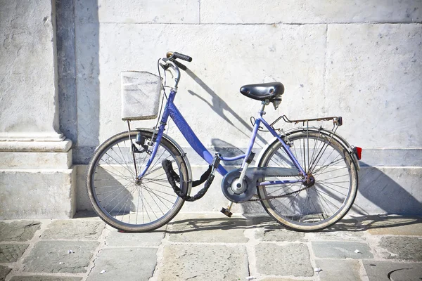 Old blue women bicycle with basket against a marble wall — Stock Photo, Image