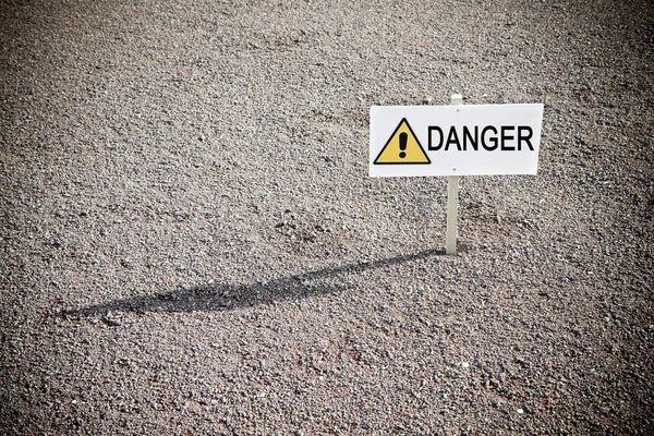 Ondertekenen in de grond met "danger" geschreven op het — Stockfoto
