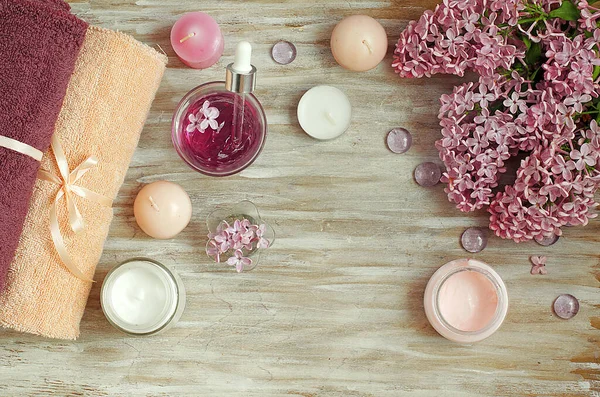 Lilac news next to organic,natural cosmetics,face towels,candles,body care.Cosmetics for relaxation, aroma.Vintage background. Free space for text. Soap. Products for massage, cream.The beauty.