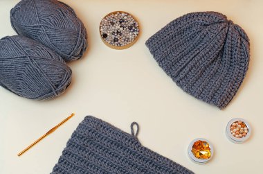 Knitted gray hat, pebbles for hand-made, for handmade. Gray beads and pebbles.Do it yourself.Crafts from threads for knitting.Acrylic thread.Pantone colors2021.Gray yellow