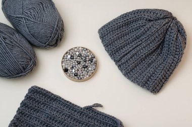 Knitted gray hat, threads for knitting, pebbles for hand-made, for handmade. To knit a hat with your own hands.Gray beads and pebbles.DIY.Do it yourself.Crafts from threads for knitting.Acrylic thread