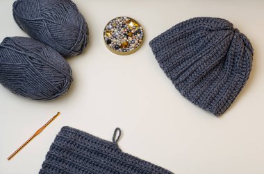 Knitted gray hat, pebbles for hand-made, for handmade. Gray beads and pebbles.Do it yourself.Crafts from threads for knitting.Acrylic thread.Pantone colors2021.Gray yellow