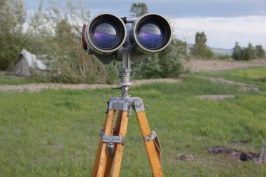 dürbün ile orman çim ile kum üzerinde bir azimut kafa ile tripod