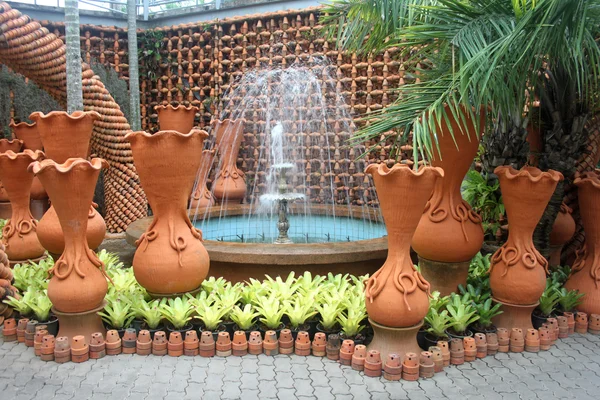 A fountain with flower pots in the Nong Nooch tropical botanic garden near Pattaya city in Thailand — Stock Photo, Image