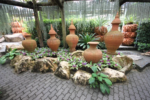 A composition of pots with flower-beds in the Nong Nooch tropical botanic garden near Pattaya city in Thailand — Stock Photo, Image