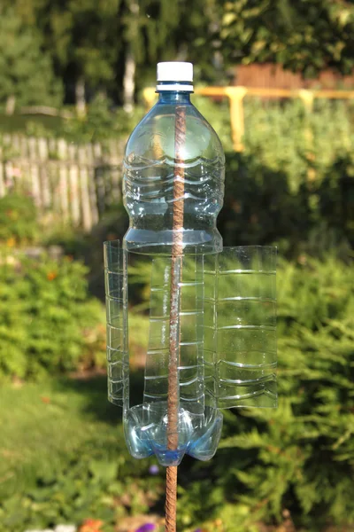 Пластикова пляшка обертається вітром і робить вібрації лякаючими моль та інших гризунів під землею Стокове Фото