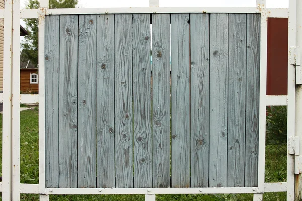 Ein graues zerlumptes Element des Zauns für den Hintergrund, Design mit rostigem Gerüst und Gras — Stockfoto