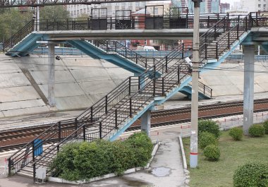 Köprünün yaya geçidi merdiven üzerinde bir tren ile