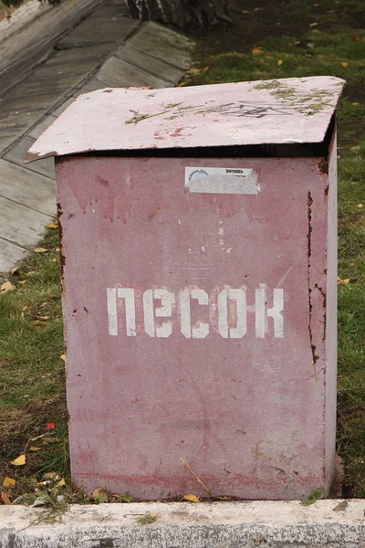 Donker-rode doos met zand, met een deksel en rust voor het blussen van branden op de herfst gras op een SNCF-station in Rusland — Stockfoto