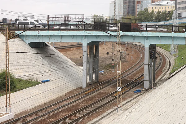 Los coches están atascados en el tráfico en un puente de carretera sobre el ferrocarril con la red de suministro eléctrico de contacto en Novosibirsk en Rusia —  Fotos de Stock